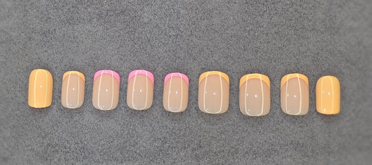 Set of press-on nails with colorful French tips in pink and orange on a gray background