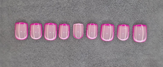 Set of pink French tip press-on nails displayed on a gray background