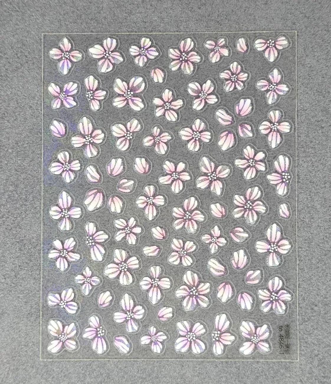 Holographic pink flower nail art stickers on gray background
