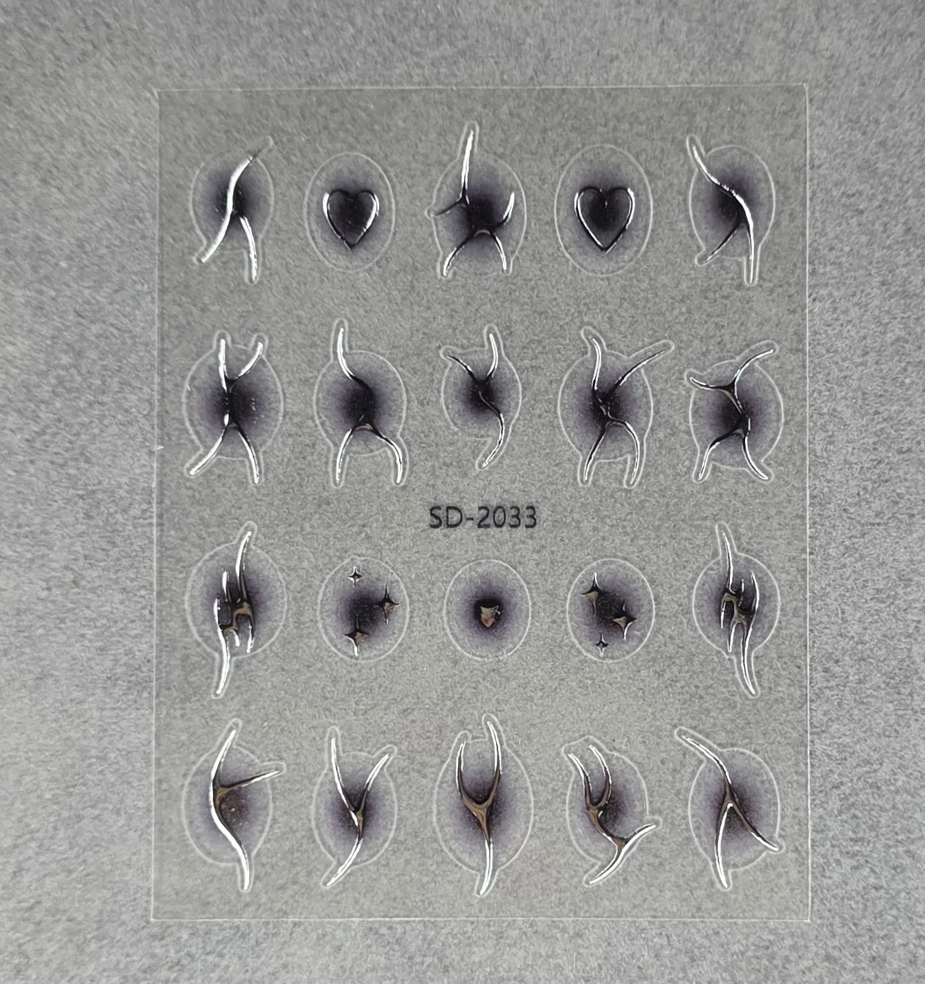 Sheet of abstract black and silver nail art stickers on transparent backing, labeled SD-2033