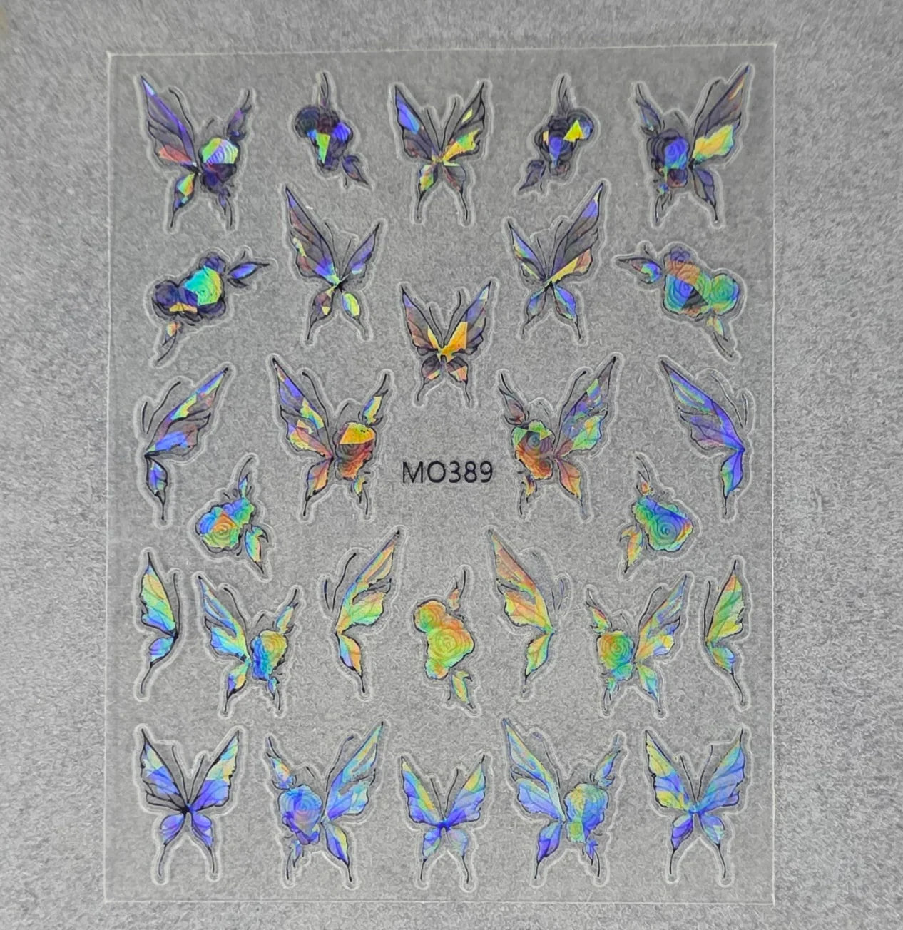 Holographic butterfly nail art stickers on clear backing sheet, design code MO389