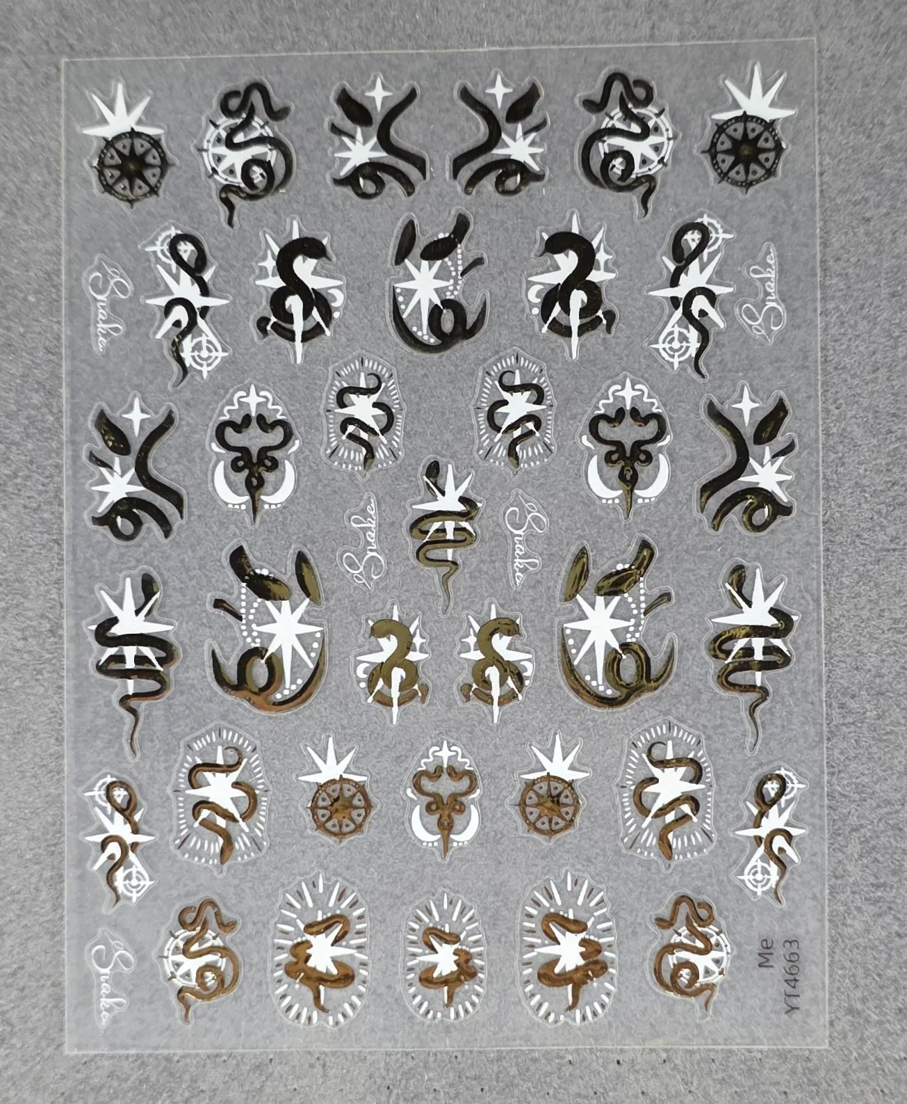 Sheet of snake and star metallic nail art stickers on a gray background