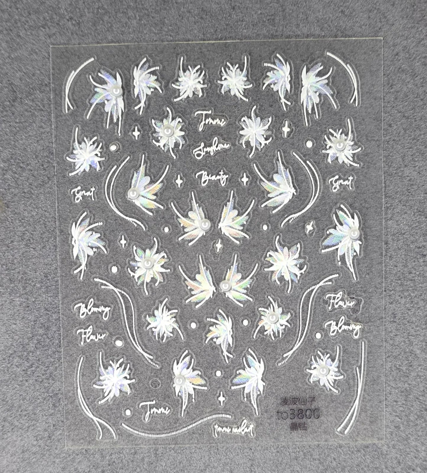 Holographic floral nail stickers with iridescent bloom designs and decorative accents on a sheet.