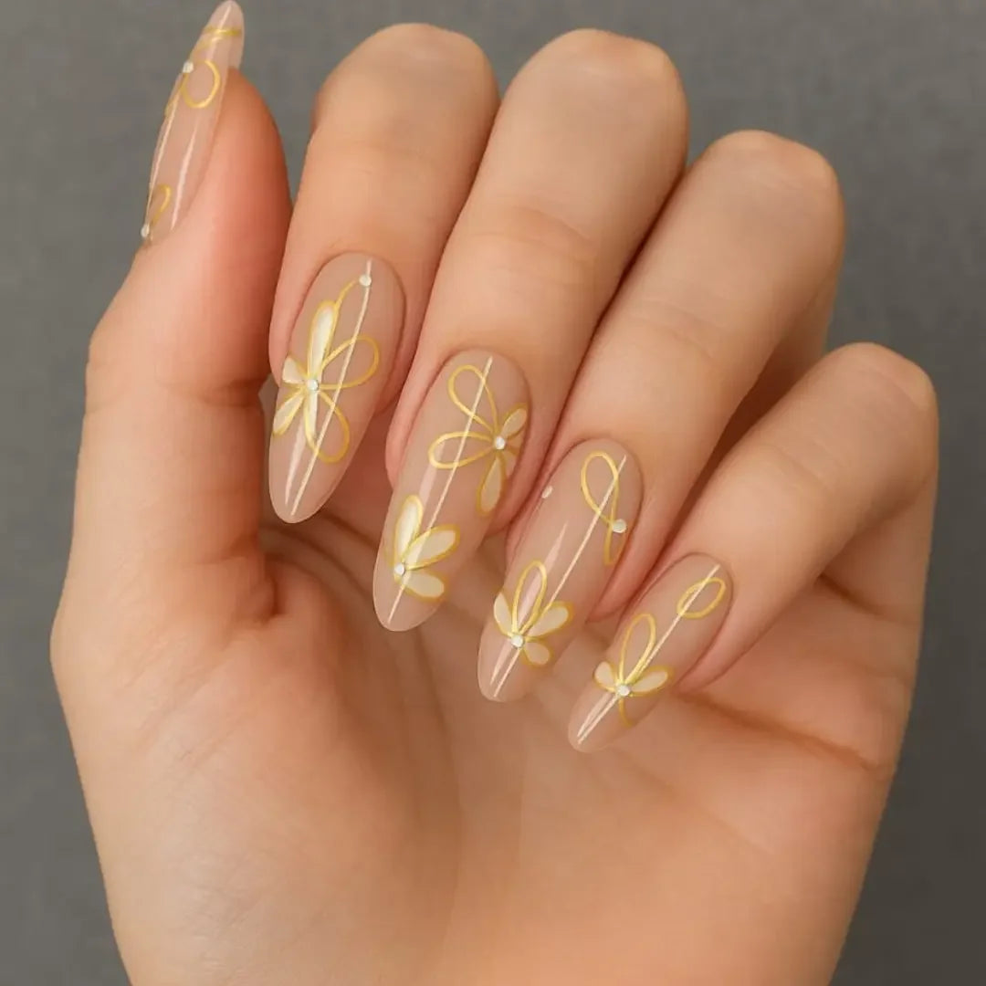 Hand with elegant nude French manicure featuring yellow daisy floral nail art.