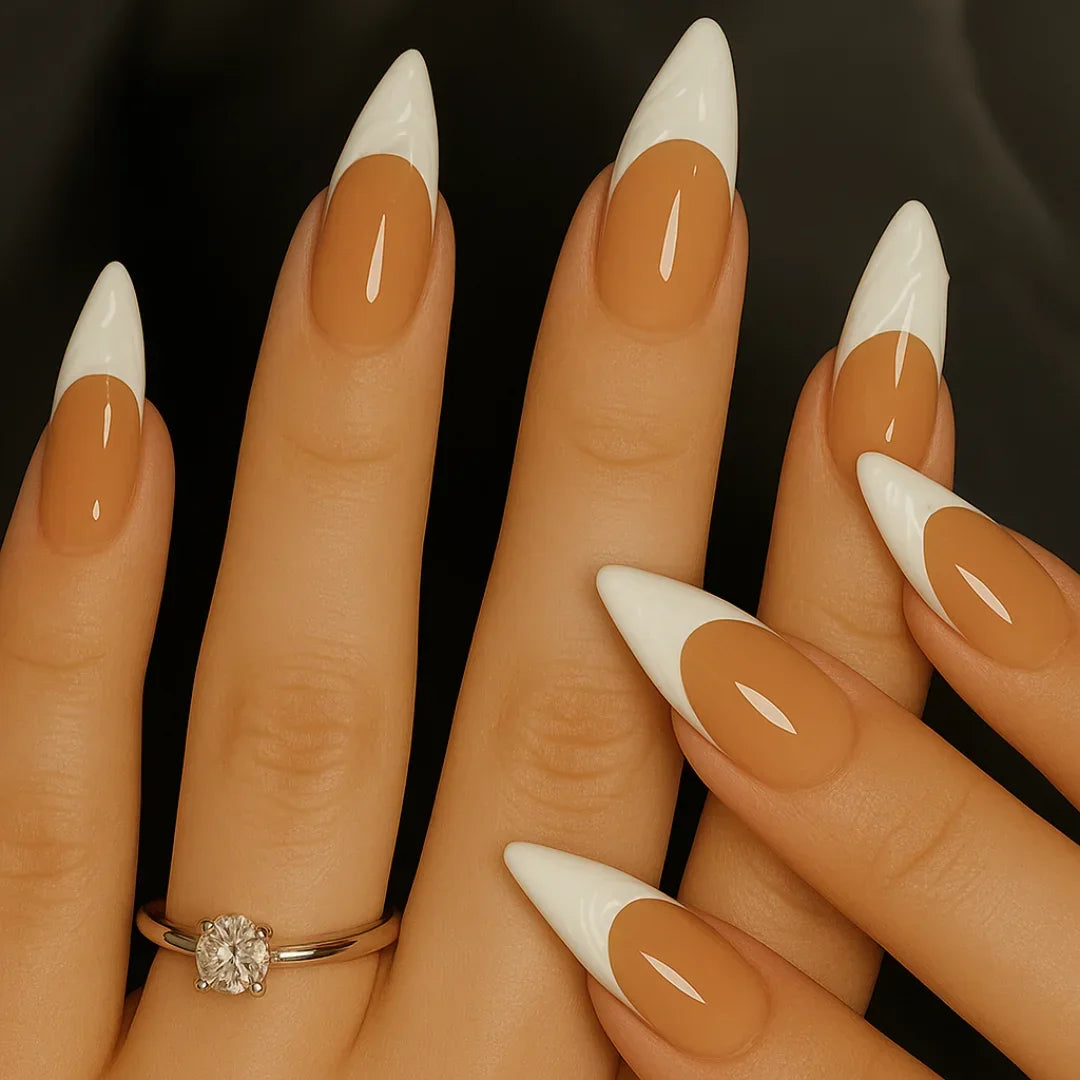Stiletto-shaped glossy white French tip press-on nails on a hand with a diamond ring