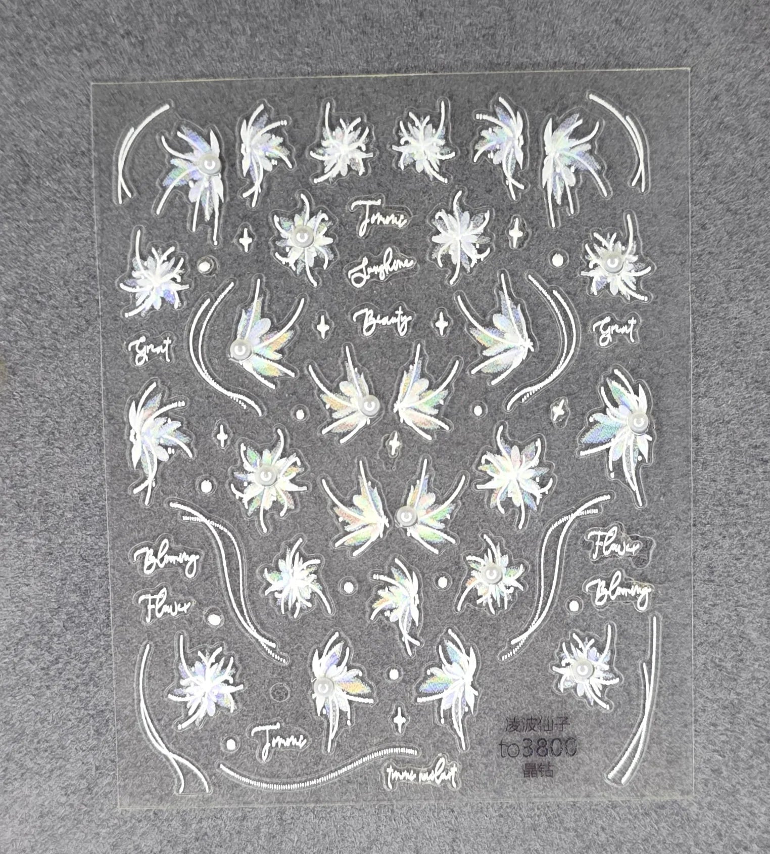 Holographic floral nail stickers with iridescent bloom designs and decorative accents on a sheet.