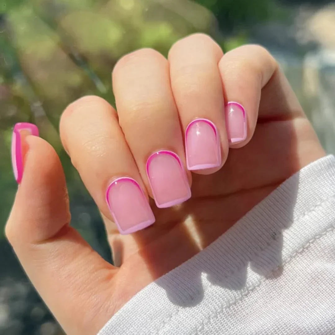 Hand with square nails featuring neon pink outline nail art design