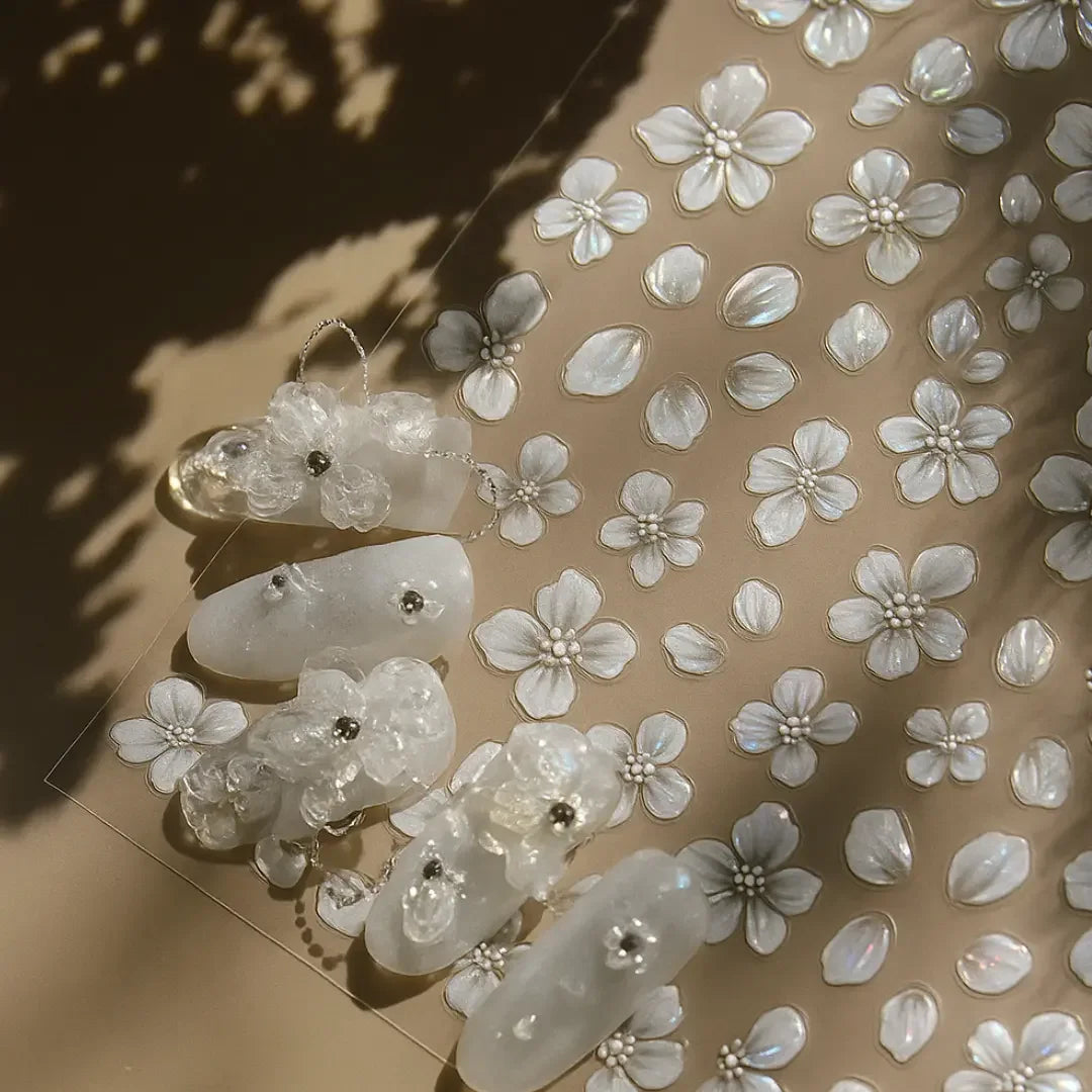 3D pearl flower nail stickers and embellished white press-on nails on beige surface