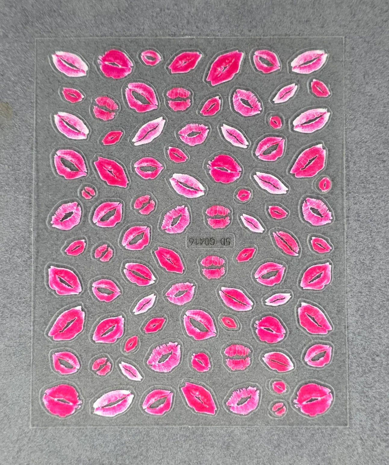 Sheet of red lip kiss nail art stickers on a gray background