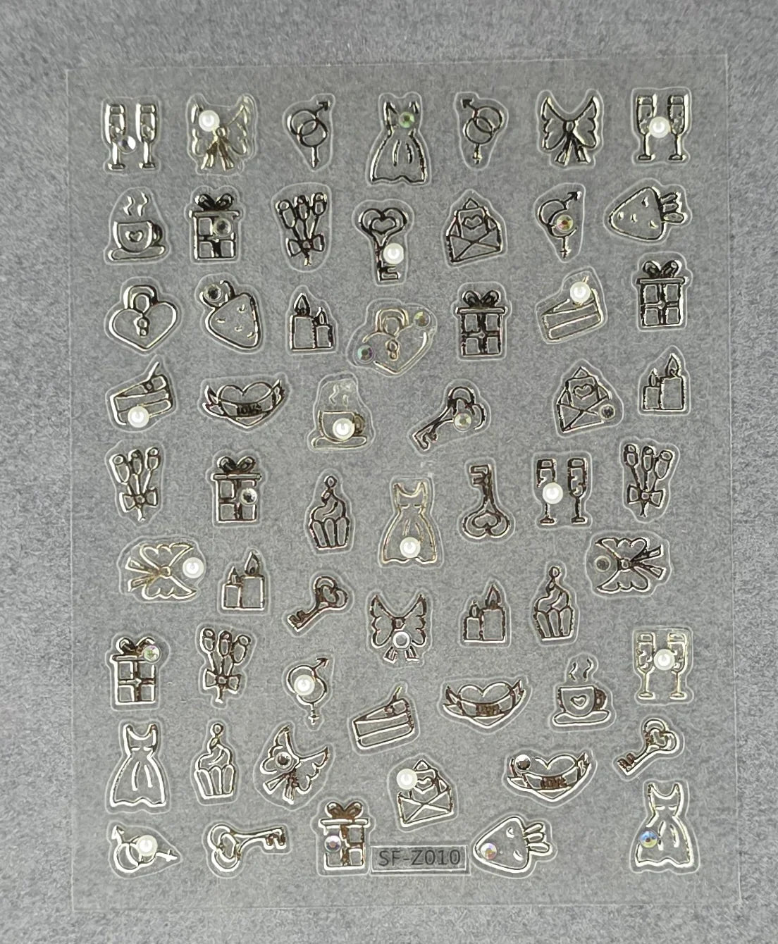 Romantic themed nail art stickers featuring hearts, keys, dresses, gifts, and cupcakes